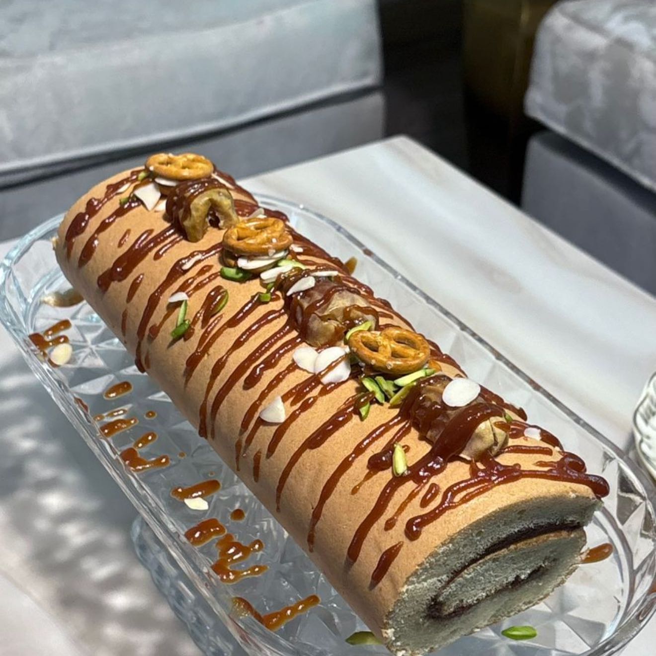 كيك رول بنكهة التمر الفاخر، طري ولذيذ بطعم متوازن يجمع بين حلا التمر ونكهة الكراميل، مزين بالمكسرات لمذاق راقٍ ومميز🌴