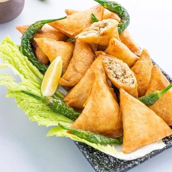 سمبوسة "الخمس نجوم" بالدجاج.. قرمشة ذهبية وحشوة ملكية! 🥟✨ لا تكتمل الضيافة الراقية إلا بـ سمبوسة الدجاج المحضرة يدوياً بكل إتقان. قمنا بتطوير وصفتنا الخاصة عبر سنوات من الخبرة لنضمن لكم طعماً أصيلاً وقواماً مثالياً يرضي ذائقتكم. ✨ ما الذي يجعل سمبوستنا استثنائية؟ القرمشة المثالية: عجينة رقيقة جداً وهشة، تُقلى بدقة لتصلكم بلون ذهبي متوهج، مع الحفاظ على قوام خفيف غير متشرب للزيت. حشوة الدجاج الغنية: نستخدم صدور الدجاج الطازجة، المفرومة والمطهوة مع توليفة من الخضار والبهارات العربية التي تمنحها طعماً يجمع بين الملوحة الموزونة والحرارة الخفيفة. هندسة اللف: كما تلاحظون في الصور، كل حبة ملفوفة بزوايا دقيقة ومنتظمة، مما يضمن ثبات الحشوة ويجعل شكلها مشرفاً جداً في صحون التقديم. لماذا تختارين "سمبوسة السبع سنوات"؟ شغل يدوي نظيف: نحضرها يومياً بمكونات طازجة 100% تماماً كما نحضرها لعائلتنا. تعدد الخيارات: نقدمها لكم جاهزة للأكل ومزينة بالفلفل والليمون، أو "مثلجة" (Frozen) لتستمتعوا بقليها طازجة في منازلكم. رفيق السفرة الدائم: هي الإضافة المثالية بجانب أطباقنا الرئيسية من الكبسة أو المكرونة لتكتمل وليمتكم. قرمشة تأخذك لعالم ثاني.. جريبها مرة وستكون طلبك الدائم في كل جمعة"